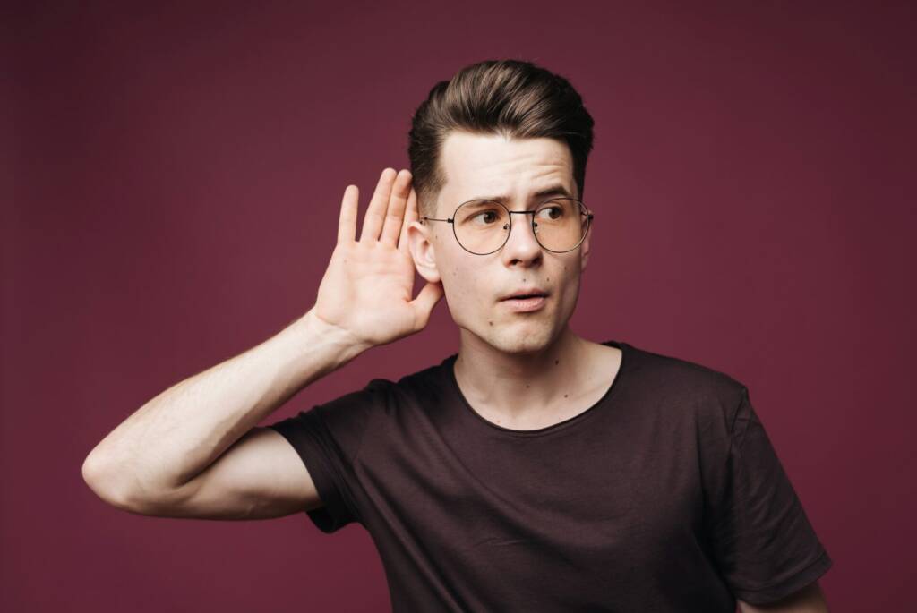 Handsome young caucasian man trying to hear something